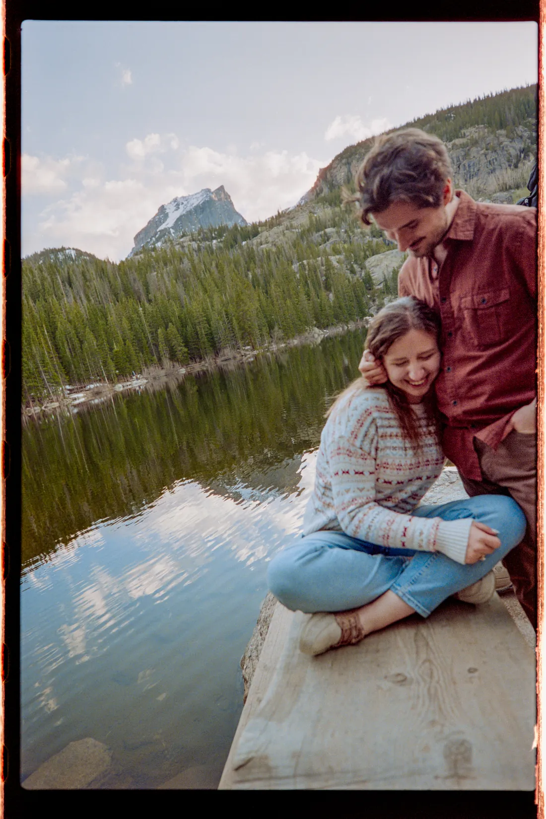 Engaged couple laughing lakeside, 35mm film photo, Rocky Mountain National Park